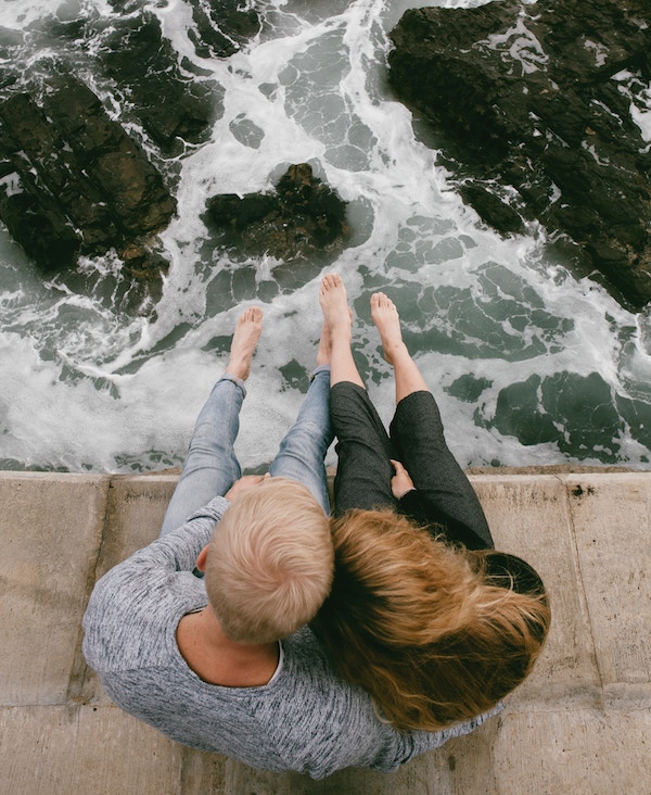  couple sitting by the water - communication with your partner is key